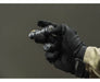 A gloved hand holds an Armytek Partner C2 Magnet USB - Warm flashlight against a plain dark background.