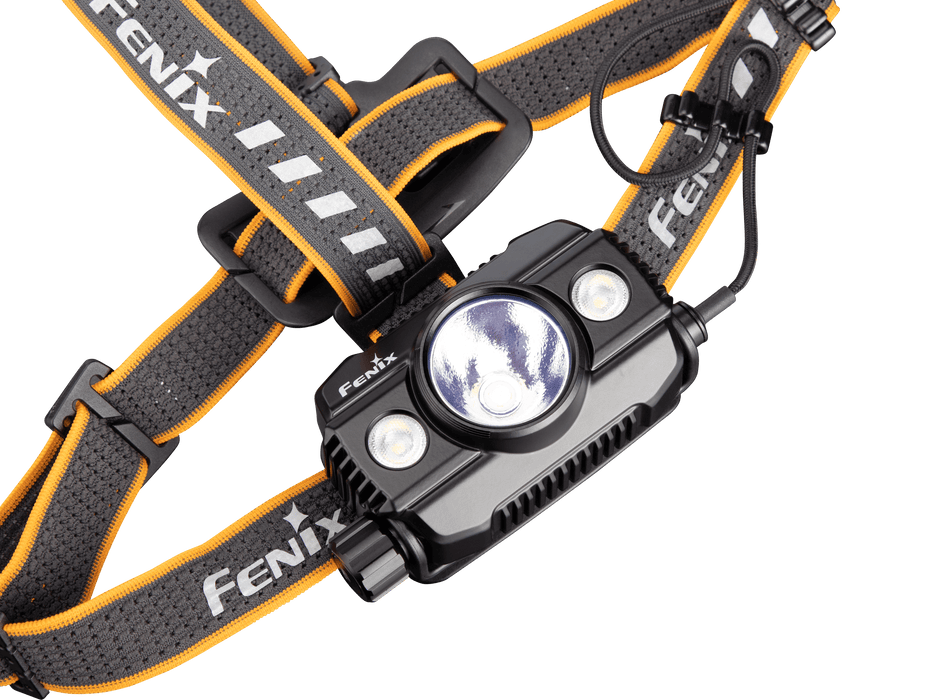 A close-up of the Fenix HP30R V2.0 headlamp showcases its black and gray design with striking orange accents. This headlamp delivers 3000 lumens through three distinct light sources and includes adjustable straps branded with "Fenix" to ensure comfort and stability.