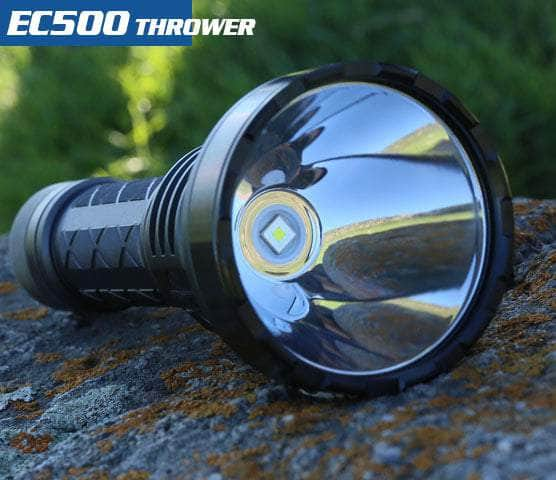 A Skilhunt EC500 USB-C rechargeable flashlight with a reflective lens sits on a rock. Text reads "EC500 Thrower," featuring 2100 lumens for an exceptional long-range flashlight experience.