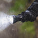 A gloved hand holds the Weltool F11R rechargeable long-range LED flashlight in the rain, with water droplets glistening on it. The beam shines brightly, showcasing the durability and efficiency of its USB-C charging structure and long battery life.