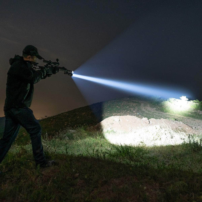 A person in dark clothing aims a rifle equipped with the Weltool F11R, a rechargeable long-range LED flashlight, illuminating the nighttime outdoor setting. The Weltool F11R features USB-C charging and boasts a long battery life.