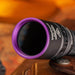 Close-up of the Weltool M4-365 UV flashlight in black metal, showcasing a purple-rimmed lens and labeled with "WO" and "MA-53A," designed for 365nm high radiation flux. The background is blurred with warm tones.